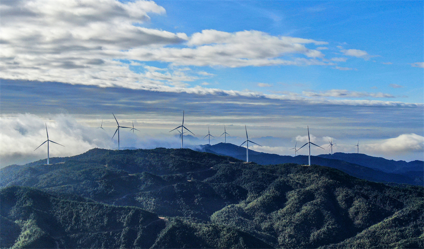 一臺臺風力發電機矗立在群山之巔，蔚為壯觀。詹繼成攝