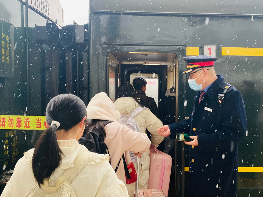 K8713次列車?？窟栒?，列車乘務員有序做好旅客乘降組織工作。周潔攝
