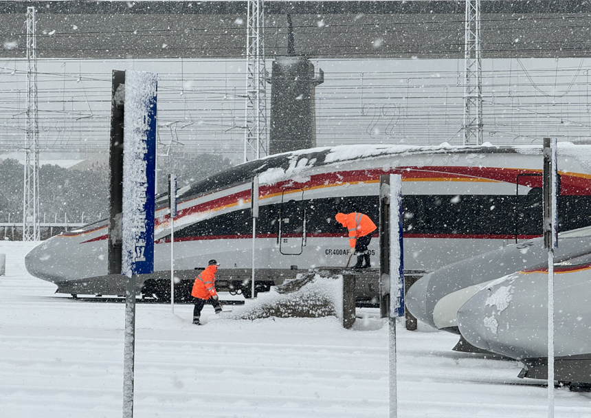 南昌車輛段工作人員在南昌西動車組運用二所對存車線進行掃雪除冰。肖堯攝
