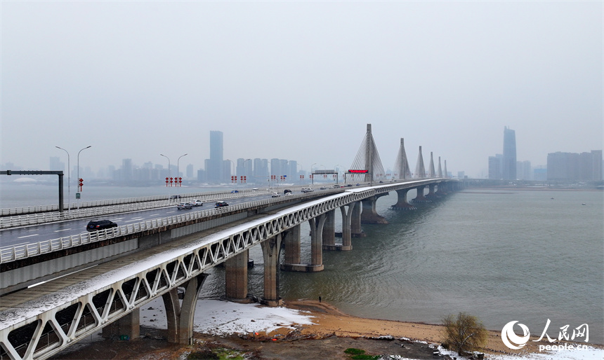 無人機航拍的南昌市紅谷灘區銀裝素裹、白雪皚皚，城市雪景美如畫。人民網 朱海鵬攝