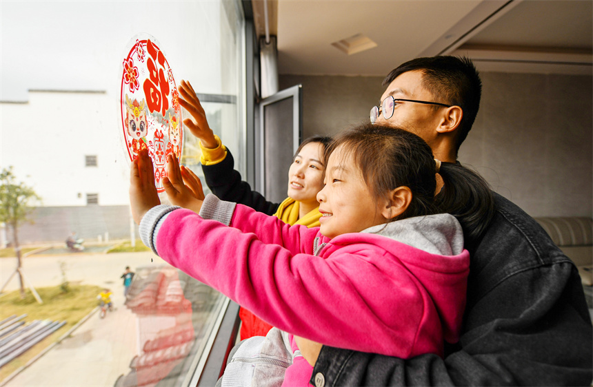 村民貼窗花喜迎新年。詹繼成攝 