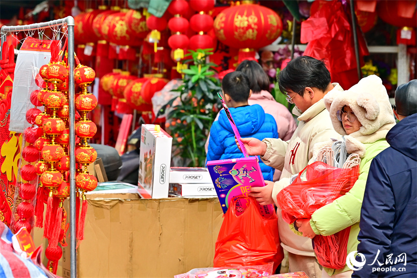 贛州市贛南貿易廣場的喜慶飾品店，市民在選購春聯、燈籠、福字。人民網 朱海鵬攝