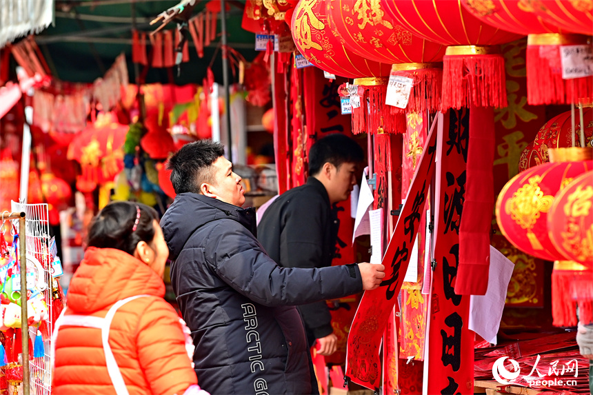 贛州市贛南貿易廣場的喜慶飾品店，市民在選購春聯、燈籠、福字。人民網 朱海鵬攝