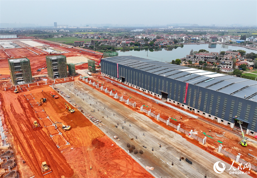 位于南昌縣的姚灣作業區綜合碼頭貨場，工人在鋪設堆場散貨倉頂棚采光板。人民網 朱海鵬攝