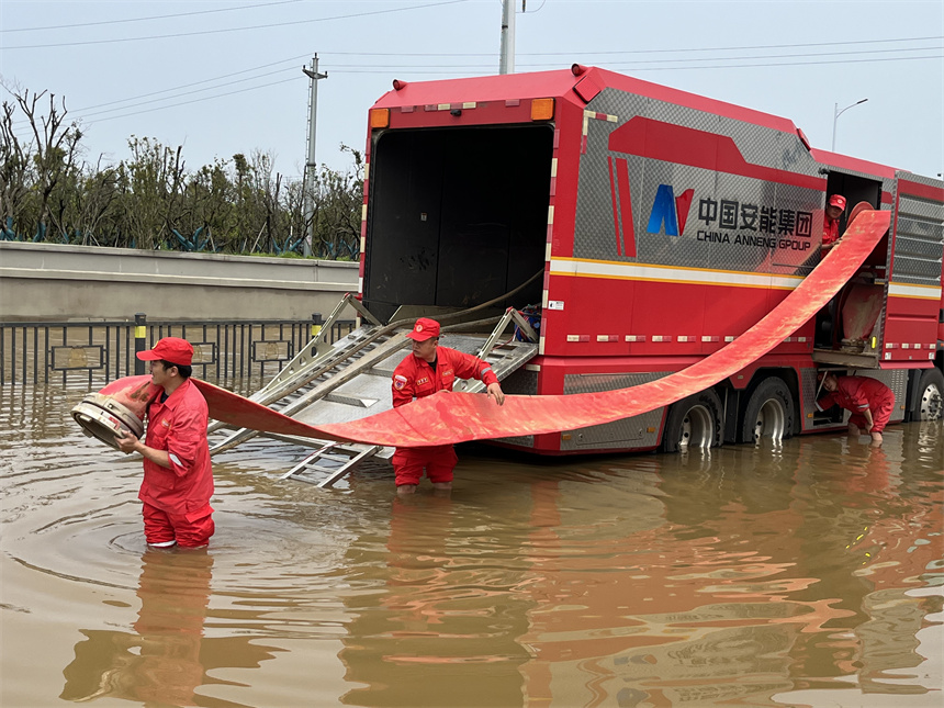 應急救援分隊隊員正使用“龍吸水”排水搶險。 徐迎華攝