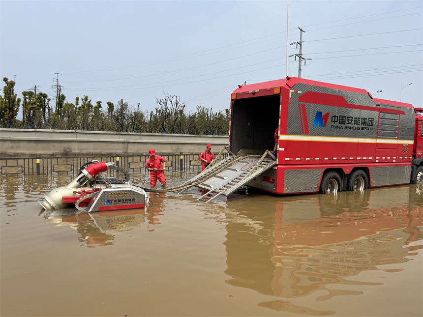 應急救援分隊隊員正使用“龍吸水”排水搶險。 徐迎華攝