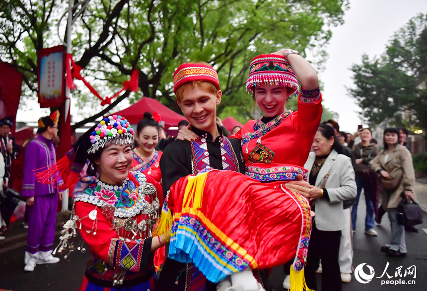 在洋林歸僑少數民族村，外國友人體驗少數民族特色婚嫁聯歡活動。 人民網記者 時雨攝