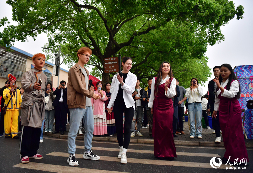 在洋林歸僑少數民族村，外國友人和村民載歌載舞。 人民網記者 時雨攝