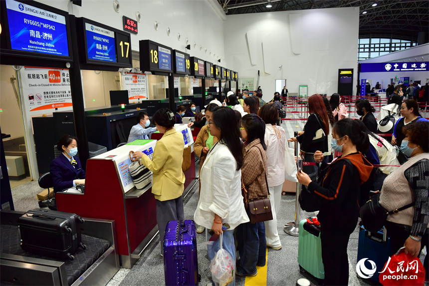 值機柜臺前，乘客們正在辦理登機手續。 人民網記者 時雨攝