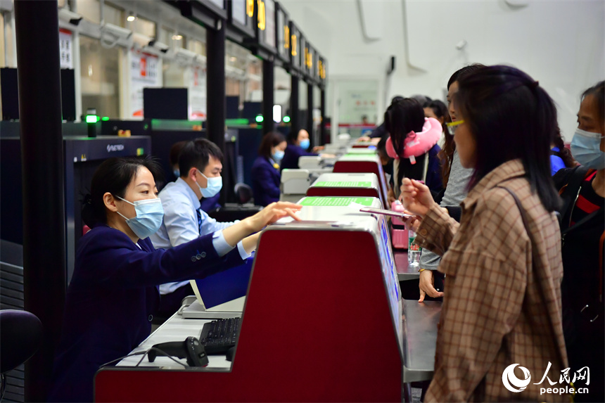 值機柜臺前，乘客們正在辦理登機手續。 人民網記者 時雨攝