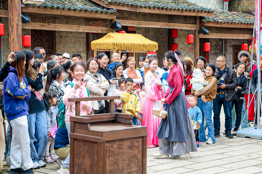 游客觀看行進式表演。