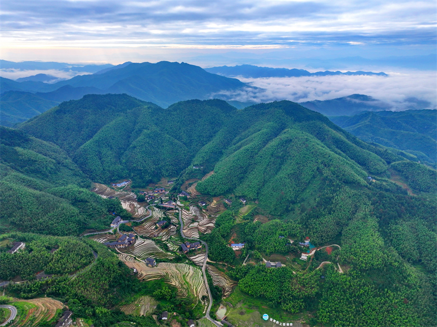 贛州市崇義縣上堡鄉，層層疊疊的梯田與森林、民宿、公路相互映襯，夏日綠色生態美景怡人。人民網 朱海鵬攝