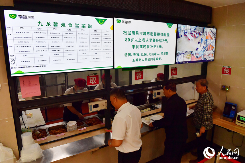 紅谷灘區九龍馨苑社區的幸福食堂里，居民們正在打菜。人民網記者 時雨攝