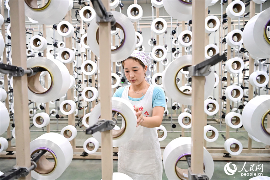 贛州市瑞金經濟技術開發區的一家紡織公司，紡織工人在織造車間加工出口服飾紡線訂單產品。人民網 朱海鵬攝
