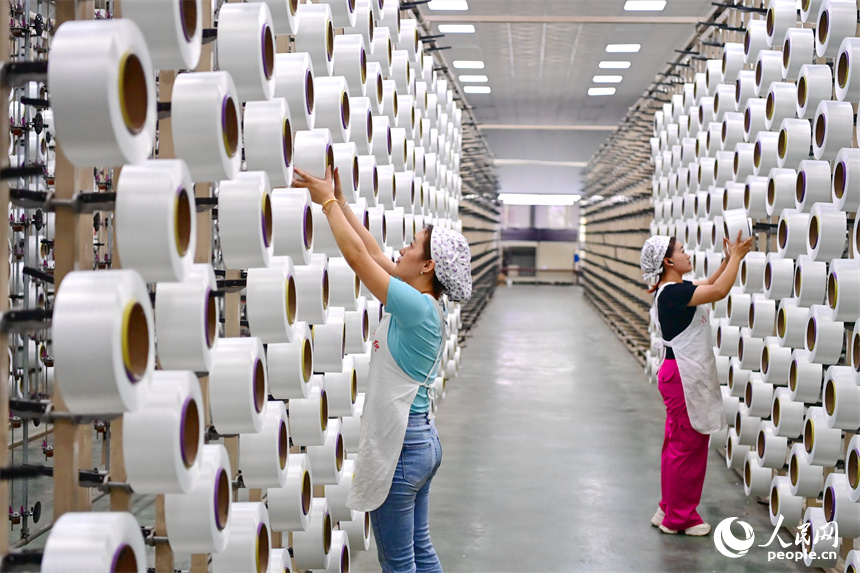 贛州市瑞金經濟技術開發區的一家紡織公司，紡織工人在織造車間加工出口服飾紡線訂單產品。人民網 朱海鵬攝