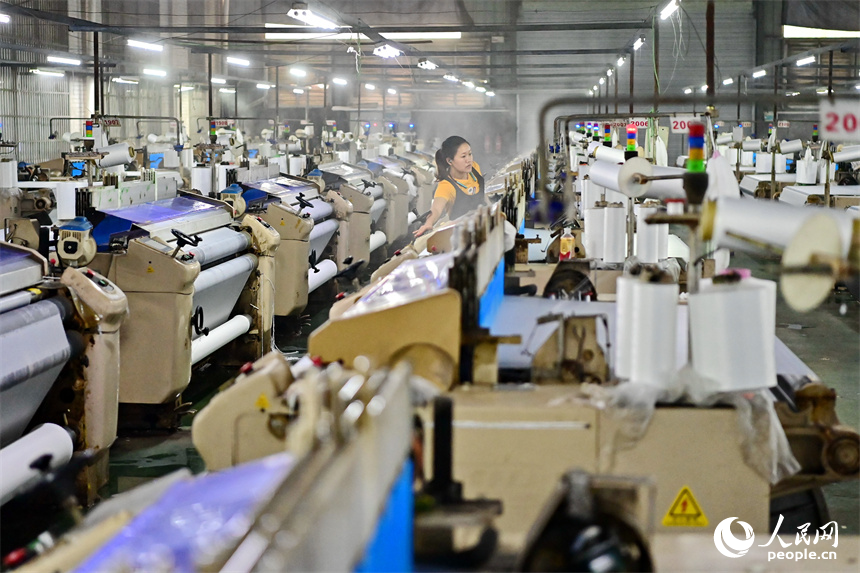 贛州市瑞金經濟技術開發區的一家紡織公司，紡織工人在織造車間加工出口服飾紡線訂單產品。人民網 朱海鵬攝