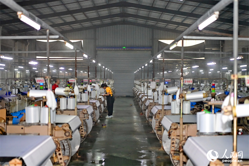 贛州市瑞金經濟技術開發區的一家紡織公司，紡織工人在織造車間加工出口服飾紡線訂單產品。人民網 朱海鵬攝