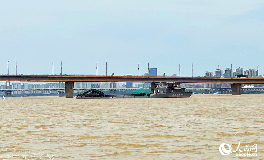 贛江水位上漲造成通航高度變小，一艘貨船即將通過南昌大橋。（手機拍攝）人民網記者 毛思遠攝