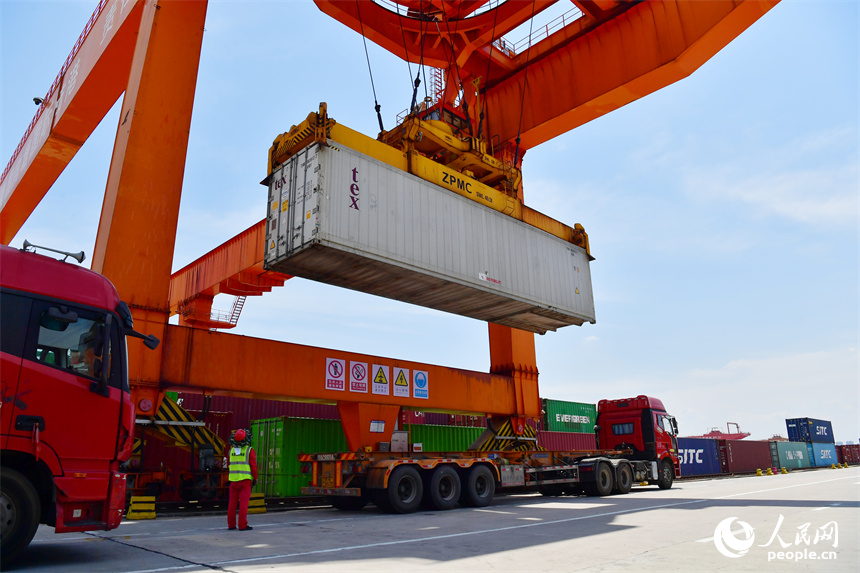 在南昌向塘國際陸港，龍門吊將冷鏈物流班列的貨箱吊運到卡車上。人民網記者 時雨攝