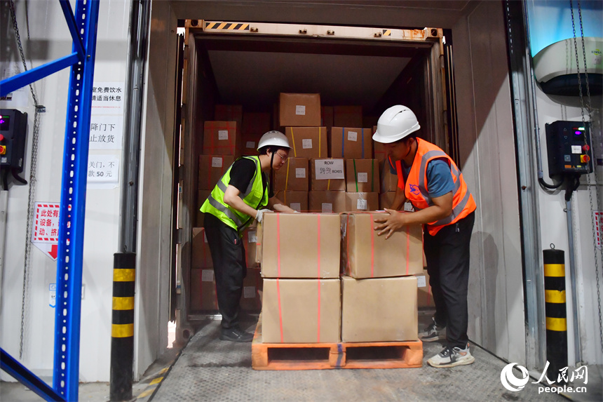 在南昌國家骨干冷鏈物流基地，工人們將冷鏈物流班列的榴蓮卸載入庫。人民網記者 時雨攝