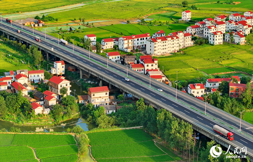 南昌縣南新鄉西江村一帶，車輛在繞城高速公路上疾馳，沿線鄉村風景怡人。人民網 朱海鵬攝