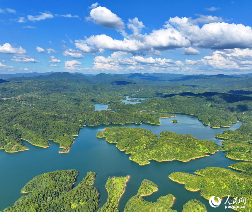 贛州市會昌縣石壁坑水庫波光粼粼，藍天白云與澄凈湖水交相輝映，構成一幅綠色生態山水畫卷。人民網 朱海鵬攝