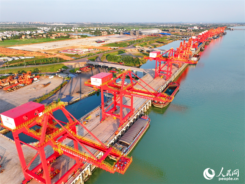 位于南昌市南昌縣的姚灣綜合碼頭，貨船、貨車來來往往，起重機裝卸作業有序進行，呈現出忙碌的景象。人民網 朱海鵬攝