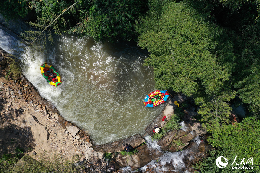 上高縣峽谷漂流水道上色彩斑斕，游客們在漂流艇上戲水消暑。人民網記者 時雨攝