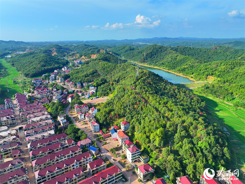 撫州市東鄉區孝崗鎮西源村的農房與通村公路、連綿青山相互映襯，美不勝收。人民網 朱海鵬攝