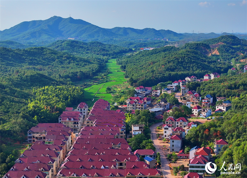 撫州市東鄉區孝崗鎮西源村的農房與通村公路、連綿青山相互映襯，美不勝收。人民網 朱海鵬攝