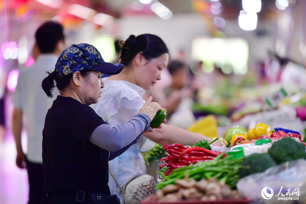 在江西省南昌市紅谷灘區沁園農貿市場內，市民正在早市購買蔬菜、肉品等。人民網記者 時雨攝