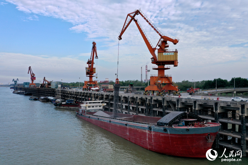 長江九江口岸瑞昌港區公用碼頭上，吊機正在往貨船上裝載建筑材料。人民網記者 時雨攝