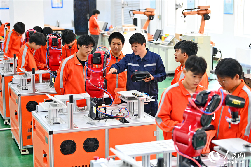 撫州市東鄉區高級技工學校的學生在練習智能機械臂編程和操作技術。人民網 朱海鵬攝
