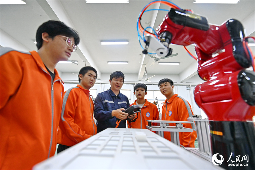 撫州市東鄉區高級技工學校的學生在練習智能機械臂編程和操作技術。人民網 朱海鵬攝