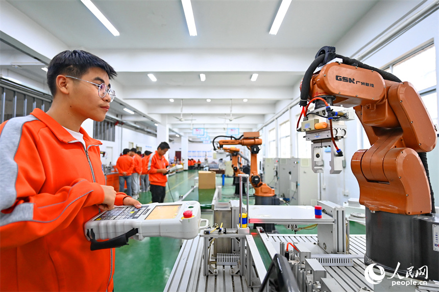 撫州市東鄉區高級技工學校的學生在練習智能機械臂編程和操作技術。人民網 朱海鵬攝