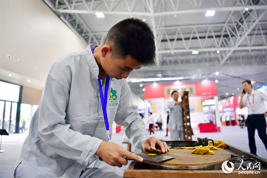 第55屆樟樹藥交會活動現場，藥工展示具有樟幫特色的炮制技藝項目。人民網記者 時雨攝