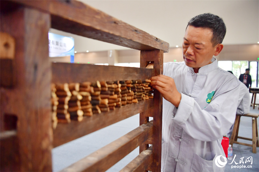 第55屆樟樹藥交會活動現場，藥工展示具有樟幫特色的炮制技藝項目。人民網記者 時雨攝