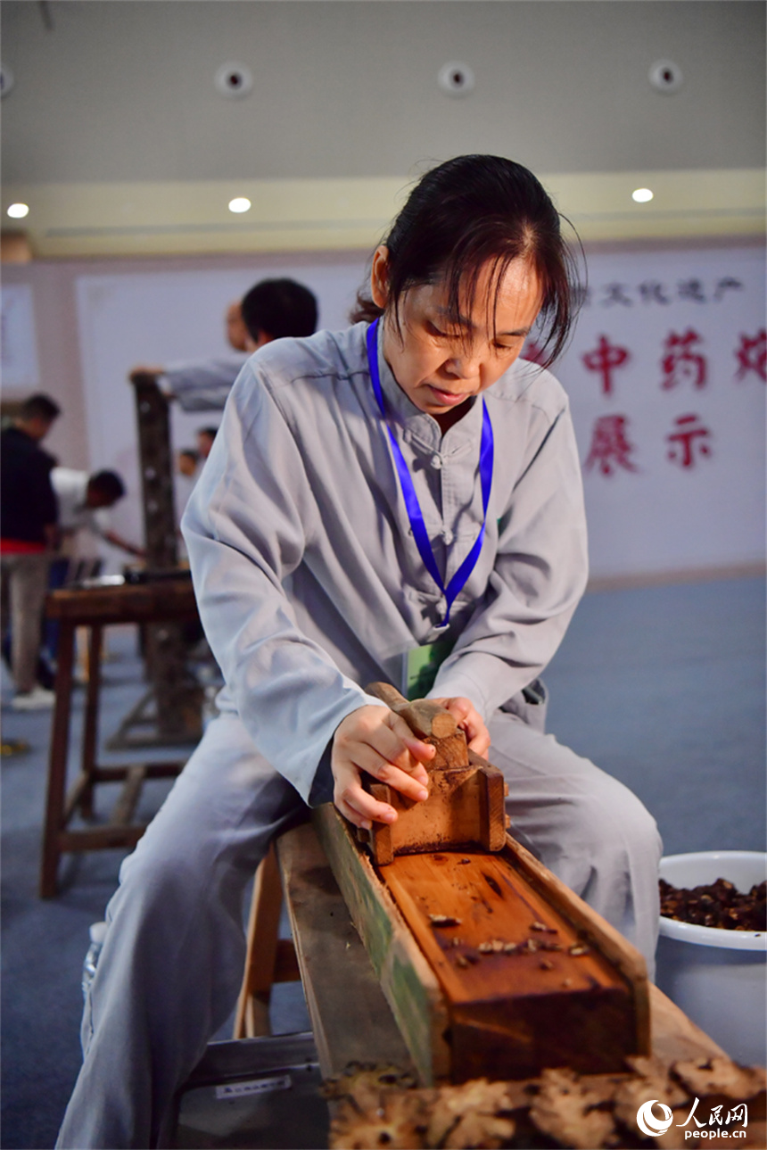 第55屆樟樹藥交會活動現場，藥工展示具有樟幫特色的炮制技藝項目。人民網記者 時雨攝