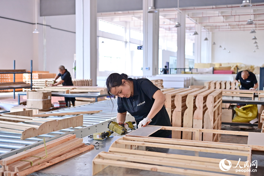 贛州市南康區經濟開發區的一家軟體家具生產企業車間內，工人在加緊制作軟包實木家具。人民網 朱海鵬攝