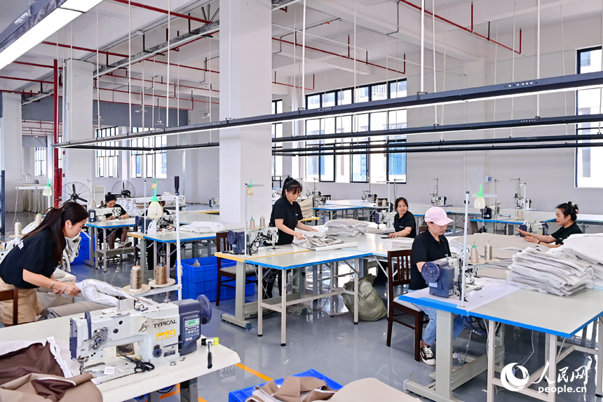 贛州市南康區經濟開發區的一家軟體家具生產企業車間內，工人在加緊制作軟包實木家具。人民網 朱海鵬攝
