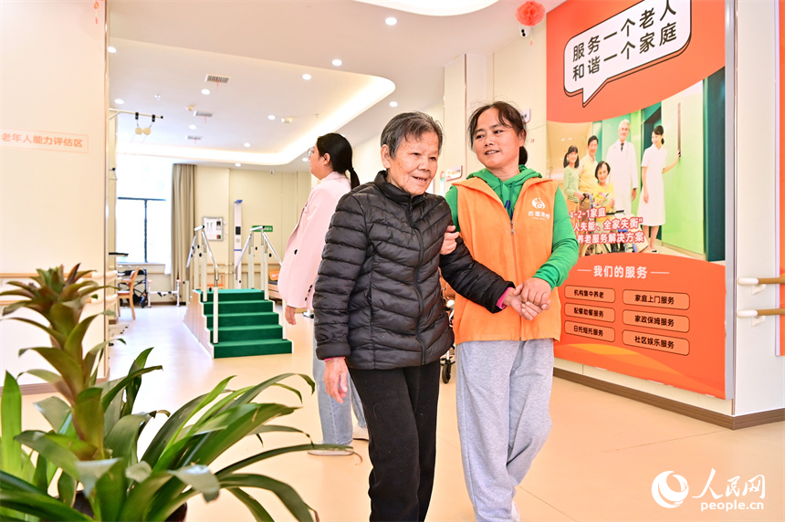 吉安市廬陵新區鳳凰社區養老中心，護工在協助老人做康復訓練。人民網 朱海鵬攝