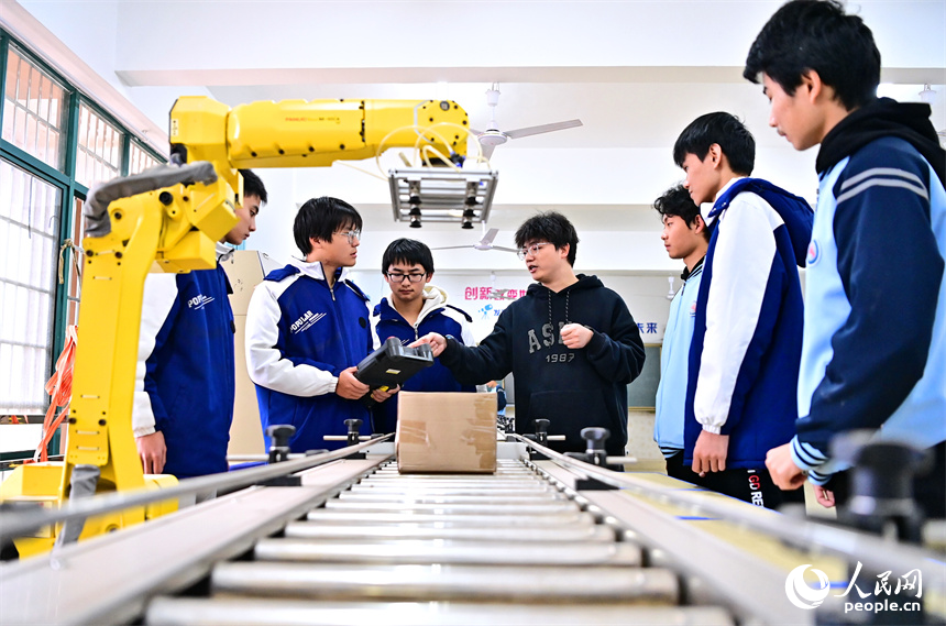 撫州市宜黃縣職業教育中心工業機器人實訓室，學生在學習工業機器人操作流程。人民網 朱海鵬攝