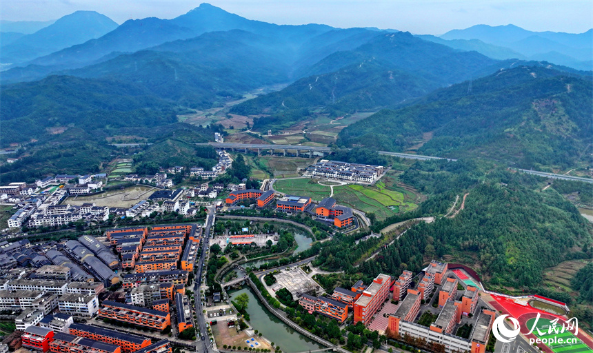 贛州市寧都縣小布鎮，鄉村公路旁的農家房屋整齊排列，與蜿蜒河流、連綿山巒相映成景。人民網 朱海鵬攝