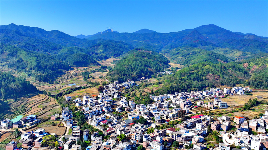 贛州市信豐縣正平鎮中壩村，綿延山巒與房屋、農田、公路相互映襯，冬景宜人。人民網 朱海鵬攝