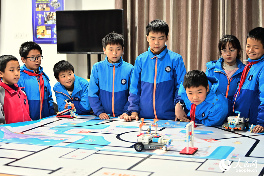 撫州市宜黃縣鳳岡鎮第一小學科普趣味課上，小學生們在體驗機器人編程組裝和模擬運行。人民網 朱海鵬攝