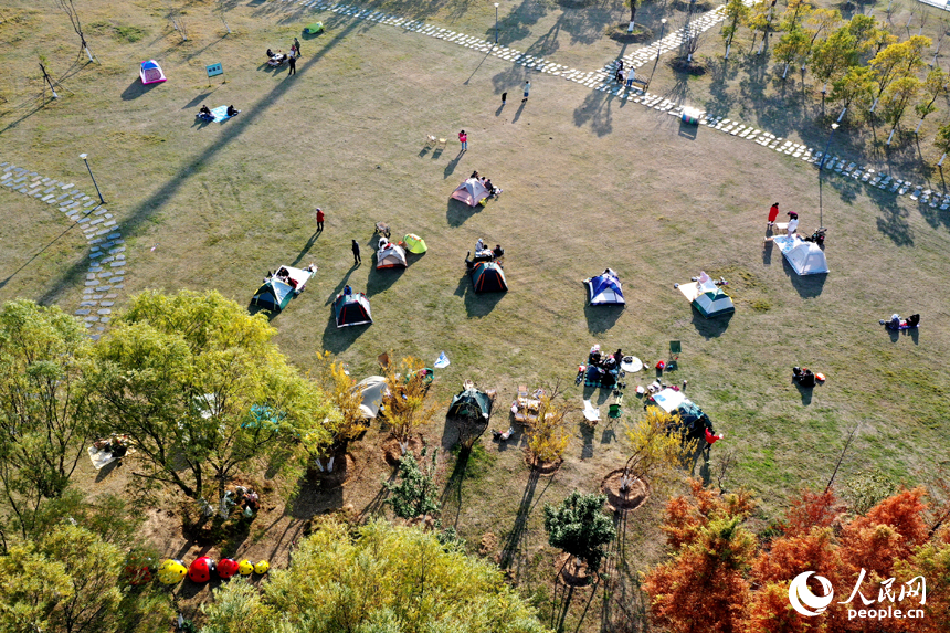 贛江市民公園里，市民們祥和悠閑的景象與公園里層林盡染、色彩斑斕的冬日美景融為一體。人民網記者 時雨攝