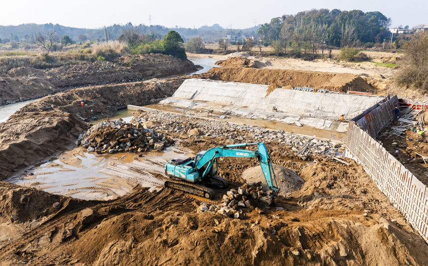 洽灣大壩工程現場，工人們正在加緊施工作業。謝東攝