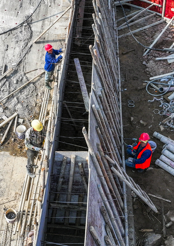 洽灣大壩工程現場，工人們正在加緊施工作業。謝東攝