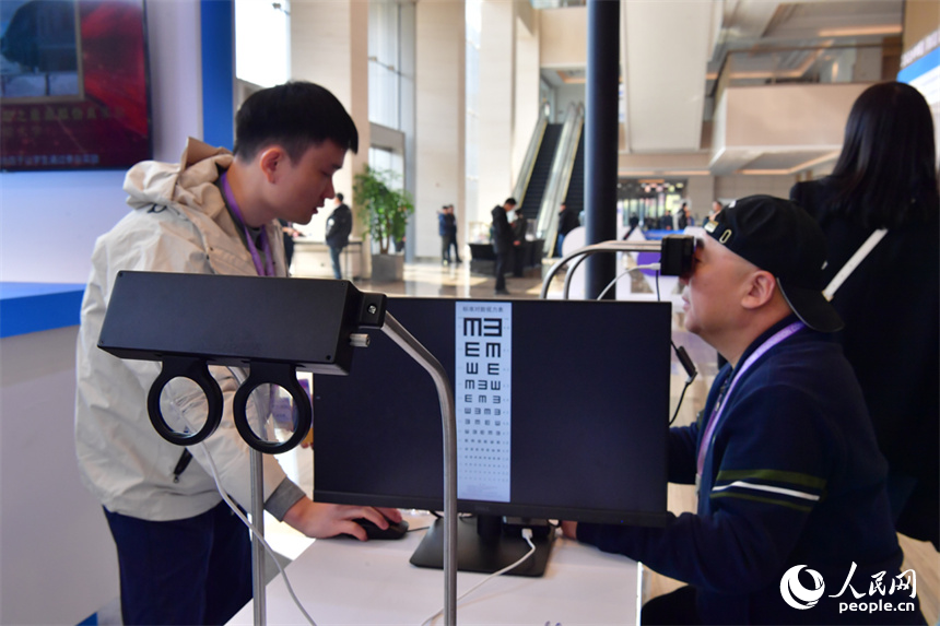 觀眾正在體驗可變焦的鏡片。人民網記者 時雨攝