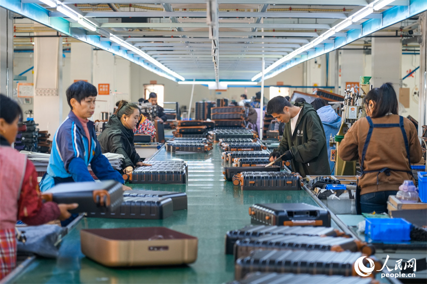 工人們正在生產線上組裝箱包。人民網 涂詩軒攝